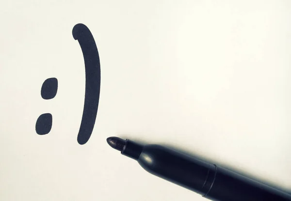 The smilie is drawn on a piece of paper — Stock Photo, Image