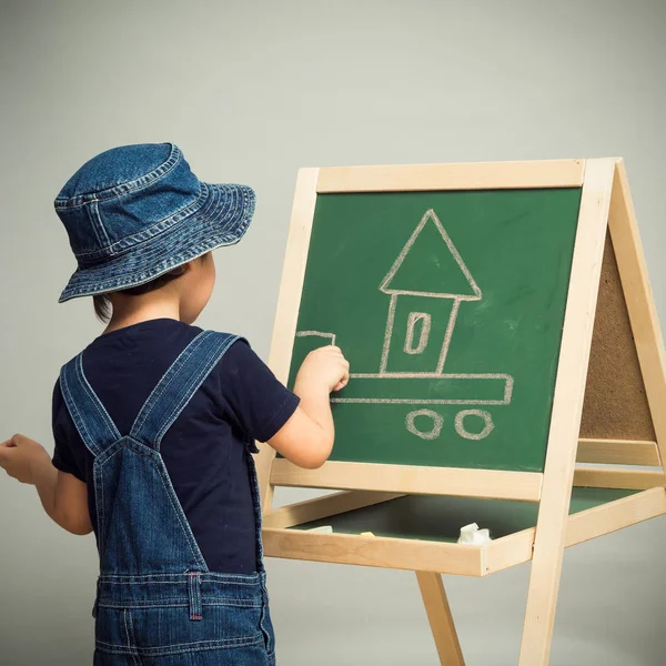Küçük çocuk tebeşir okul tahtaya çizer. — Stok fotoğraf