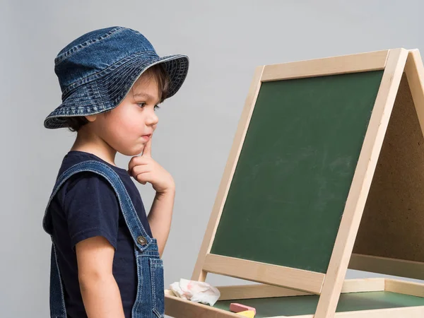Küçük çocuk tebeşir okul tahtaya çizer. — Stok fotoğraf