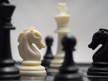 bir satranç tahtası üzerinde siyah ve beyaz satranç taşları