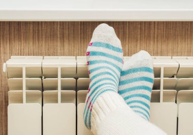 Kadın ayakları üzerinde bir kalorifer radyatör