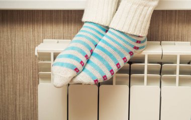 Kadın ayakları üzerinde bir kalorifer radyatör