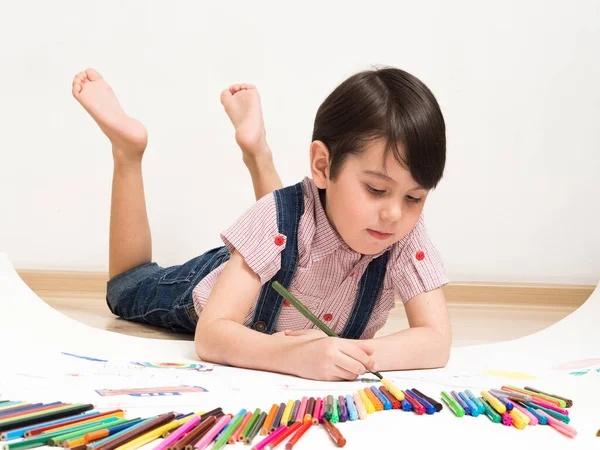 Маленький Мальчик Рисует Лежа Полу — стоковое фото