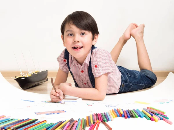 Ein Kleiner Junge Zeichnet Während Auf Dem Boden Liegt — Stockfoto