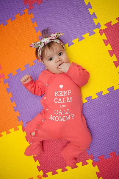 Imádnivaló és elegáns baba lány feküdt egy puzzle szőnyeg — Stock Fotó