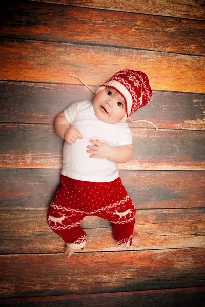 Il bambino piccolo in berretto rosso di Babbo Natale festeggia il Natale. Foto di Natale del bambino in berretto rosso — Foto Stock