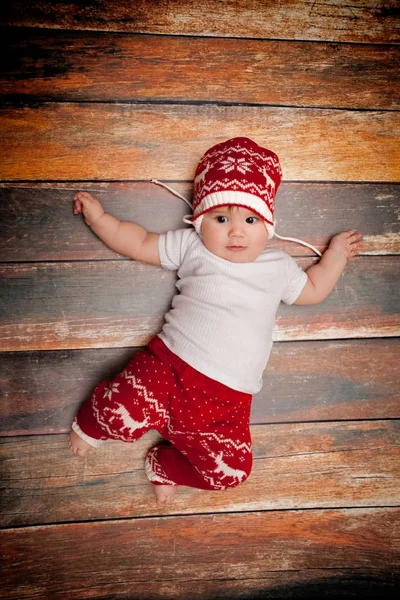 Il bambino piccolo in berretto rosso di Babbo Natale festeggia il Natale. Foto di Natale del bambino in berretto rosso Foto Stock