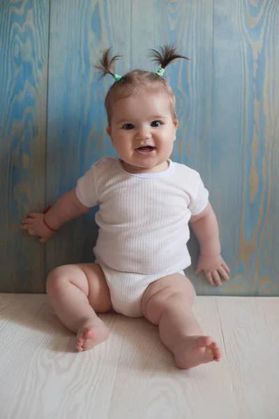 Schattig babymeisje met zittend op een houten vloer — Stockfoto