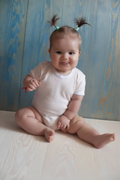 Adorable Baby Girl z siedzącej na drewnianą podłogę — Zdjęcie stockowe
