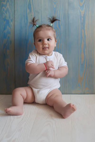 Adorable bébé fille avec assise sur un sol en bois — Photo
