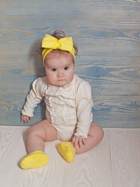 Adorable bébé fille avec assise sur un sol en bois — Photo