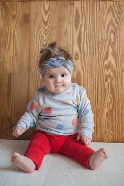 Schattig babymeisje met zittend op een houten vloer — Stockfoto