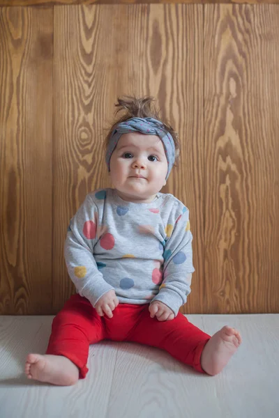 Sevimli bebek ile ahşap bir katta oturan kız — Stok fotoğraf