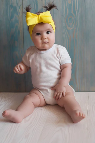 Adorabile bambina con seduta su un pavimento di legno — Foto Stock