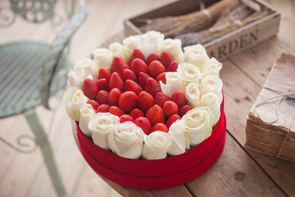 Den svatého Valentýna pozadí. Krabice ve tvaru srdce čerstvé jahody s květinami — Stock fotografie