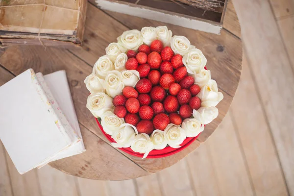 Den svatého Valentýna pozadí. Krabice ve tvaru srdce čerstvé jahody s květinami — Stock fotografie