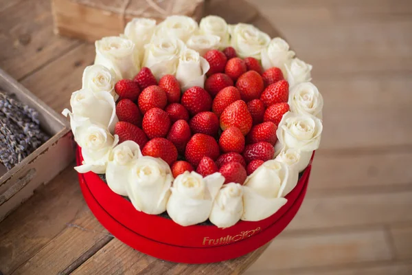 Alla hjärtans dag bakgrund. Rutan i hjärtformade färska jordgubbar med blommor — Stockfoto