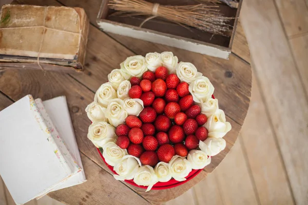 Φόντο ημέρα του Αγίου Βαλεντίνου. Το κουτί με σχήμα καρδιάς φρέσκες φράουλες με λουλούδια — Φωτογραφία Αρχείου