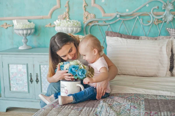 Portrait intérieur de jeune belle femme profitant de son heure du matin à la maison avec son bébé fille — Photo