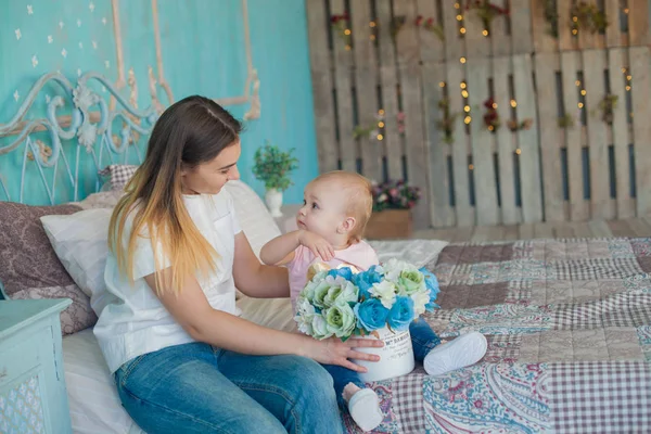 Indoor portret van jonge mooie vrouw genieten van haar 's morgens tijd thuis met haar babymeisje — Stockfoto