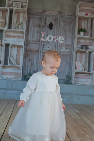 Heel schattig klein meisje Blond in een witte jurk op kamer in vintage stijl — Stockfoto