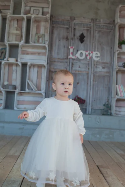 Heel schattig klein meisje Blond in een witte jurk op kamer in vintage stijl — Stockfoto