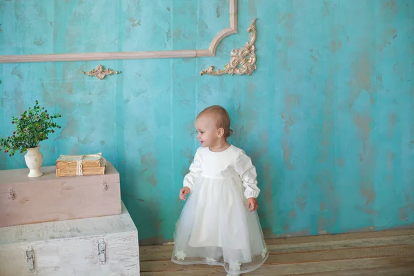 Heel schattig klein meisje Blond in een witte jurk op kamer in vintage stijl — Stockfoto