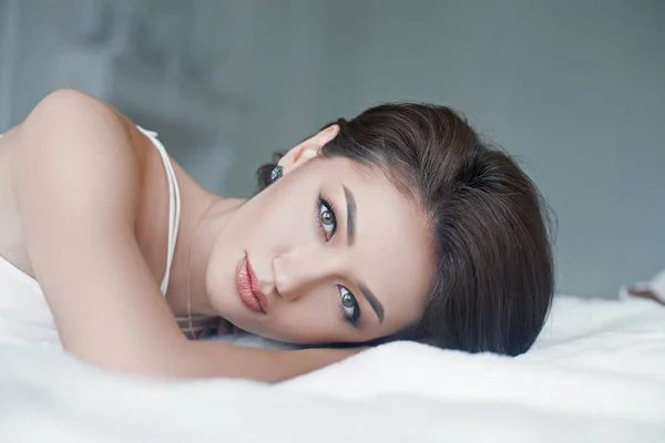 Sensuell och vacker kvinna i vit klänning i sängen — Stockfoto