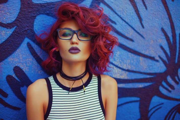 街道外观时尚和性感的女人与红色卷曲的发型在涂鸦墙附近 — 图库照片