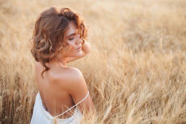 Bir yaz gün batımı beyaz buğday alanda kadın