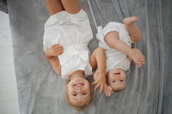 Vista Superior Criança Sorridente Segurando Mão Irmãzinha Deitada Cama Branca — Fotografia de Stock