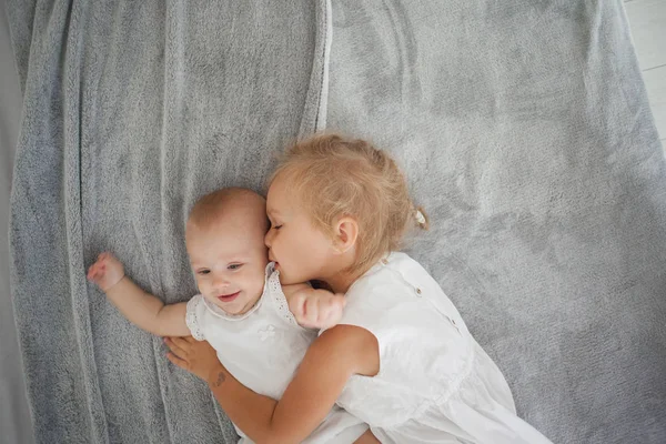 Ovanifrån Leende Barn Håller Hand Lillasyster Liggande Vit Sängkläder — Stockfoto