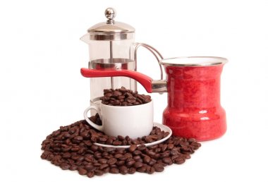 Kahve çekirdekleri ve beyaz arka plan üzerinde beyaz bir fincan