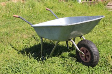 Yeşil çimenlerin üzerinde eski metal el arabası