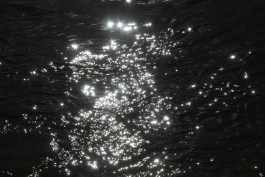 Parlak güneş ışığı altında su yüzeyine