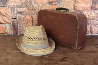 Eski bavul ve şapka ahşap bir masada.