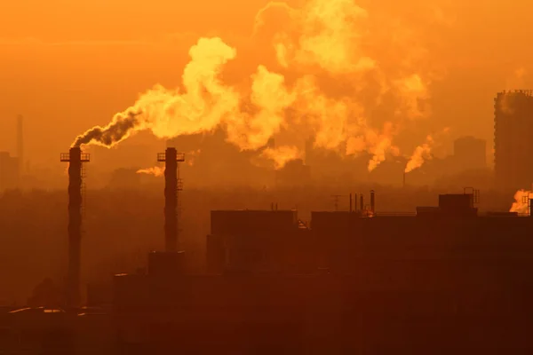 Smoke from a factory chimney against evening sky. Image on theme of global warming