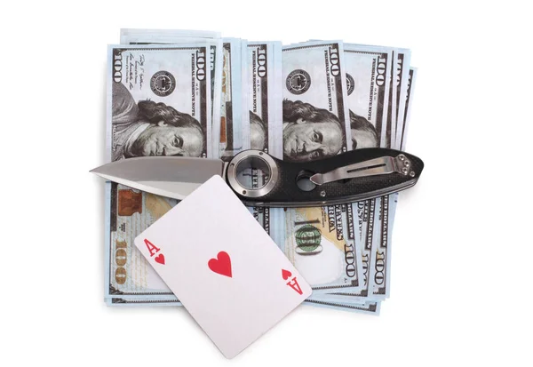 Folding knife and playing cards lie on paper dollars. Isolated objects on a white background