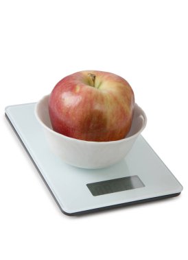 Büyük kırmızı elma beyaz arka planda mutfak terazisinde