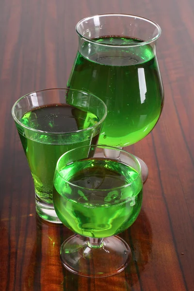桌上放有绿色鸡尾酒的玻璃瓶 — 图库照片