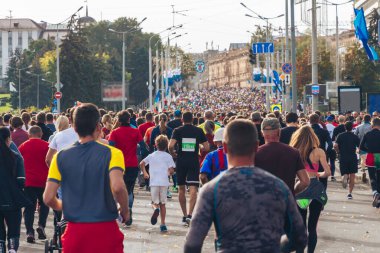 Birçok sporcu bir şehir yolunda maraton koşar..