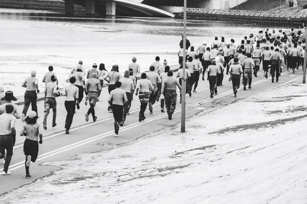 Muitos homens nus em trajes de cavaleiro correm no inverno — Fotografia de Stock