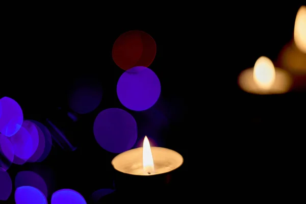 Ljuset brinner på bakgrunden av juldekorationer — Stockfoto