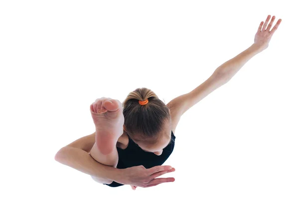 Ένα κοριτσάκι σε ένα κοστούμι γυμναστικής σηκώνει το πόδι της n Κάτοψη — Φωτογραφία Αρχείου