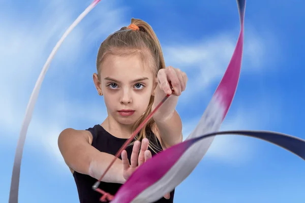 Молода дівчина спортсменка з білими зачісками зі стрічкою гімнастики — стокове фото