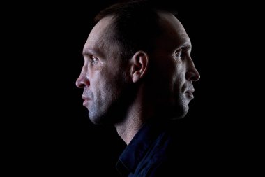 Siyah gömlekli, esmer, ciddi bir adam.