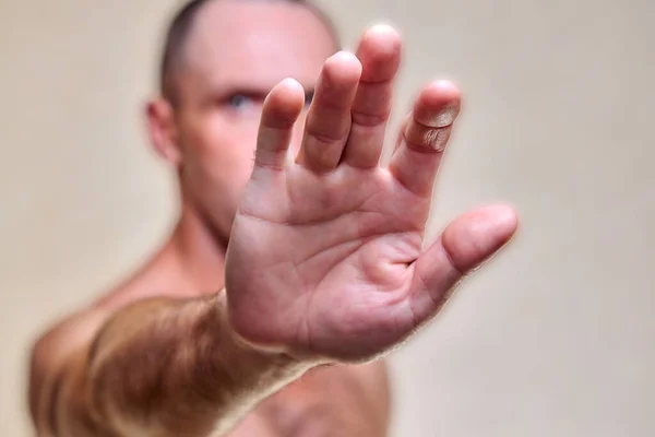 Scared man put his hands forward. Athlete fenced off