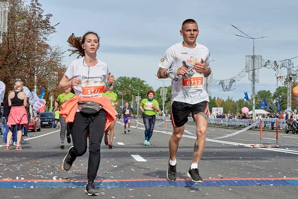2019年9月15日 一场马拉松赛 一名年轻男子和一名女子在城市公路上完成马拉松赛 — 图库照片
