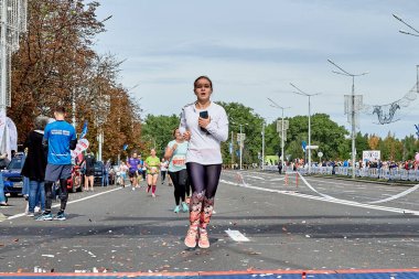 15 Eylül 2019 Minsk Belarus. Telefonu olan aktif bir kız maratonun bitiş çizgisine koşuyor.