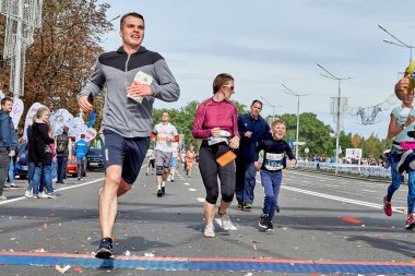 15 Eylül 2019 Minsk Belarus Yarışmacıları ve küçük bir çocuk şehir yolundaki maratonun bitiş çizgisini geçtiler.